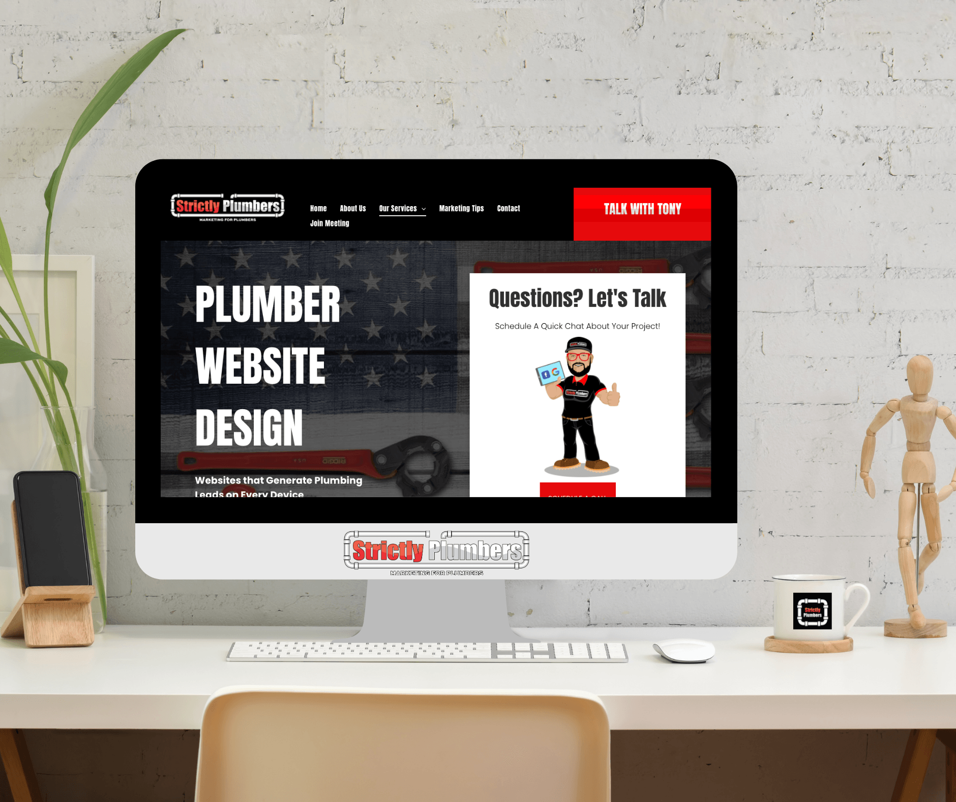 A computer is sitting on a desk with a plumber website design on the screen.