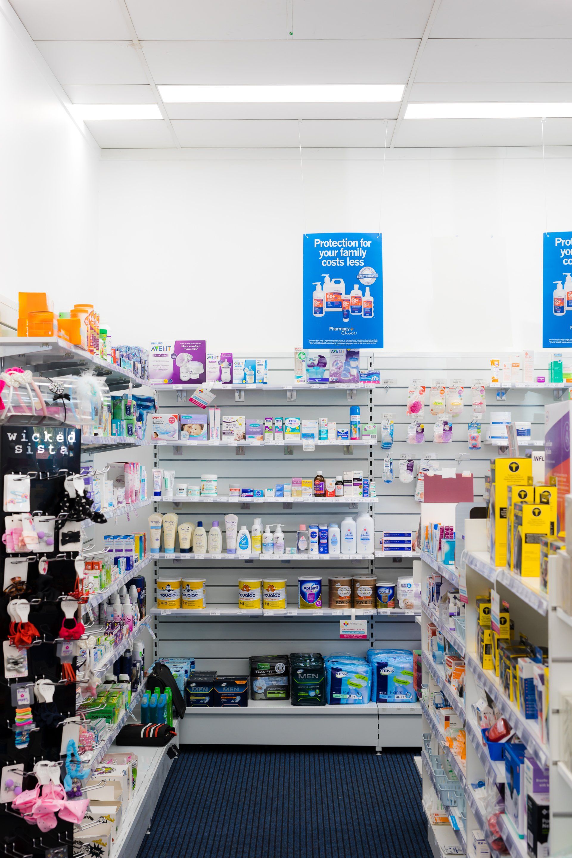 Store aisle with baby products on shelves and a blue sign overhead