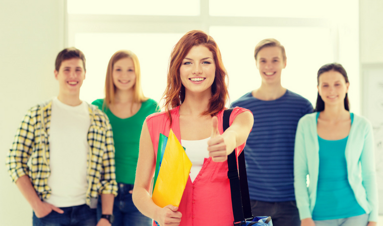 A group of young people are standing next to each other in a hallway.