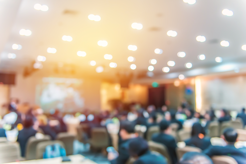 a blurry picture of a group of people sitting in a conference room .