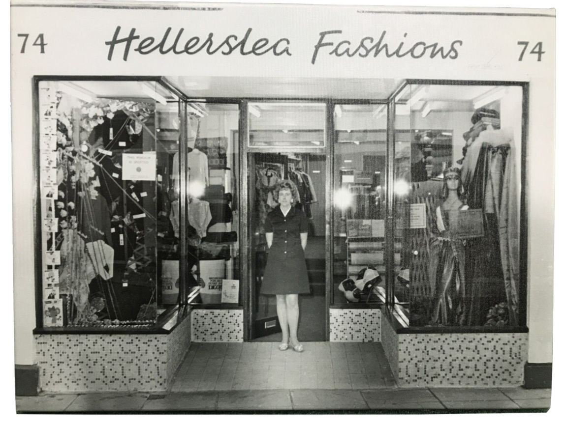 Black and white photo of a woman standing in the doorway of