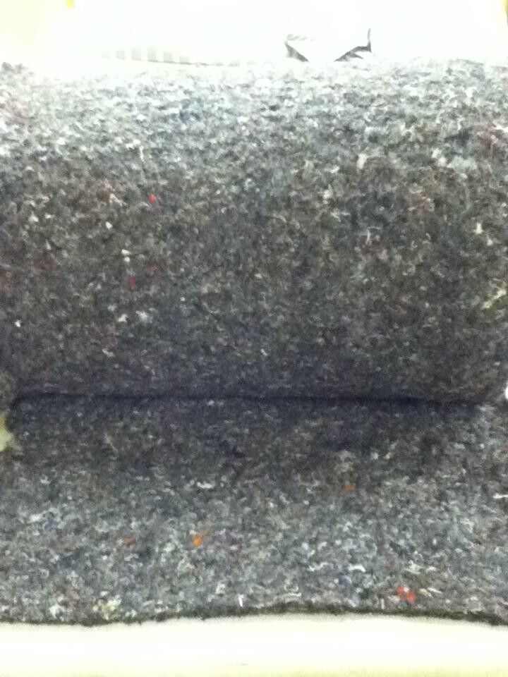 Rolled gray felt fabric, close-up, revealing layers.