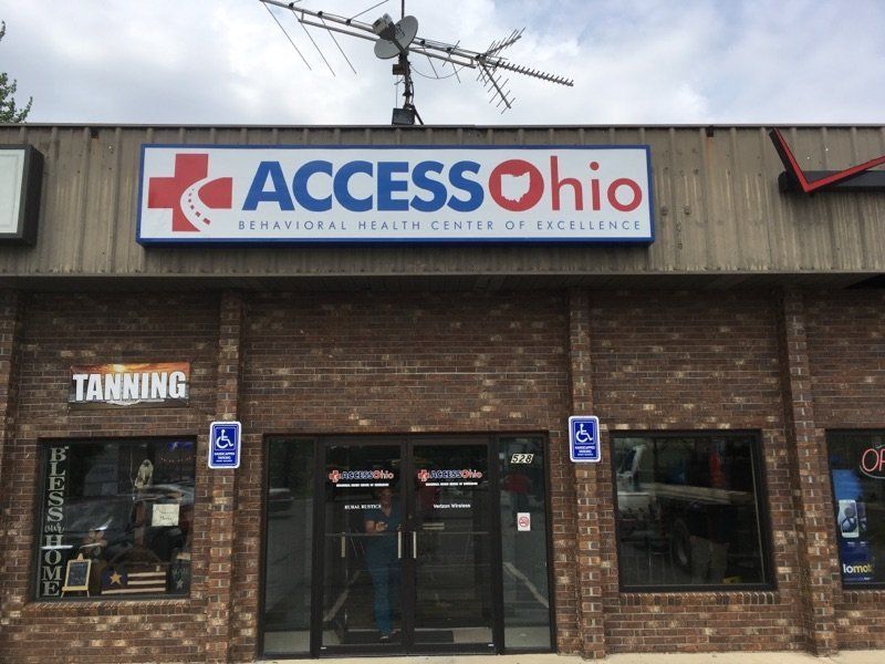 Access Ohio storefront with brick facade, glass doors, and handicap parking signs under the sign.
