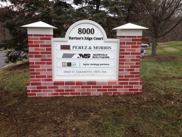 Brick monument sign for Perez & Morris at 8000 Raven’s Edge Court, with white pillars and landscaping.