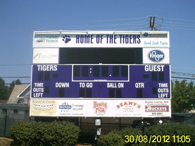 Football scoreboard reading “Home of the Tigers” with Tigers and Guest sections against a blue sky