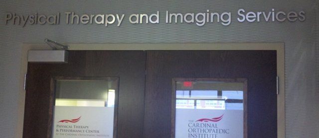Entrance to Physical Therapy and Imaging Services with dark doors and frosted glass panels
