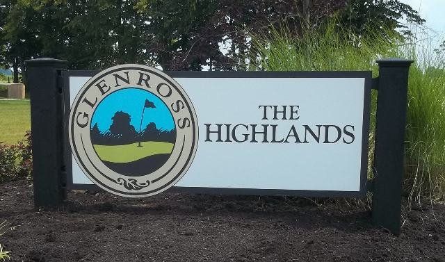 Sign for Glenross The Highlands with circular logo and landscape graphic in a landscaped outdoor setting