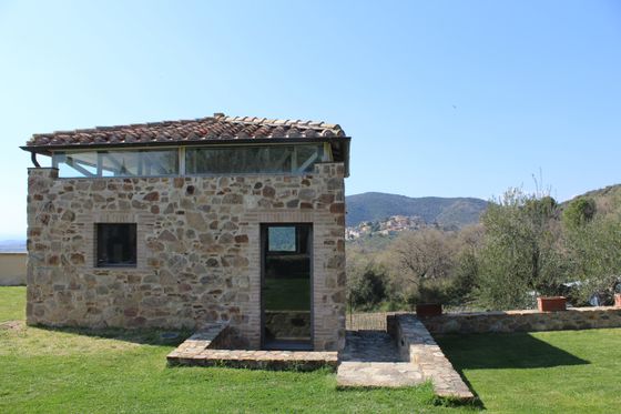 casetta in pietra ristrutturata con sfondo collinare