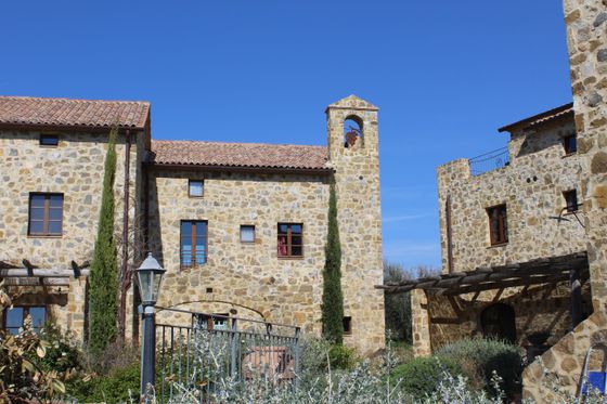 villa con torrretta in pietra e cipressi