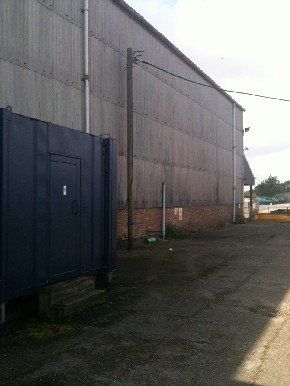 The outside of a warehouse from a concrete drive.