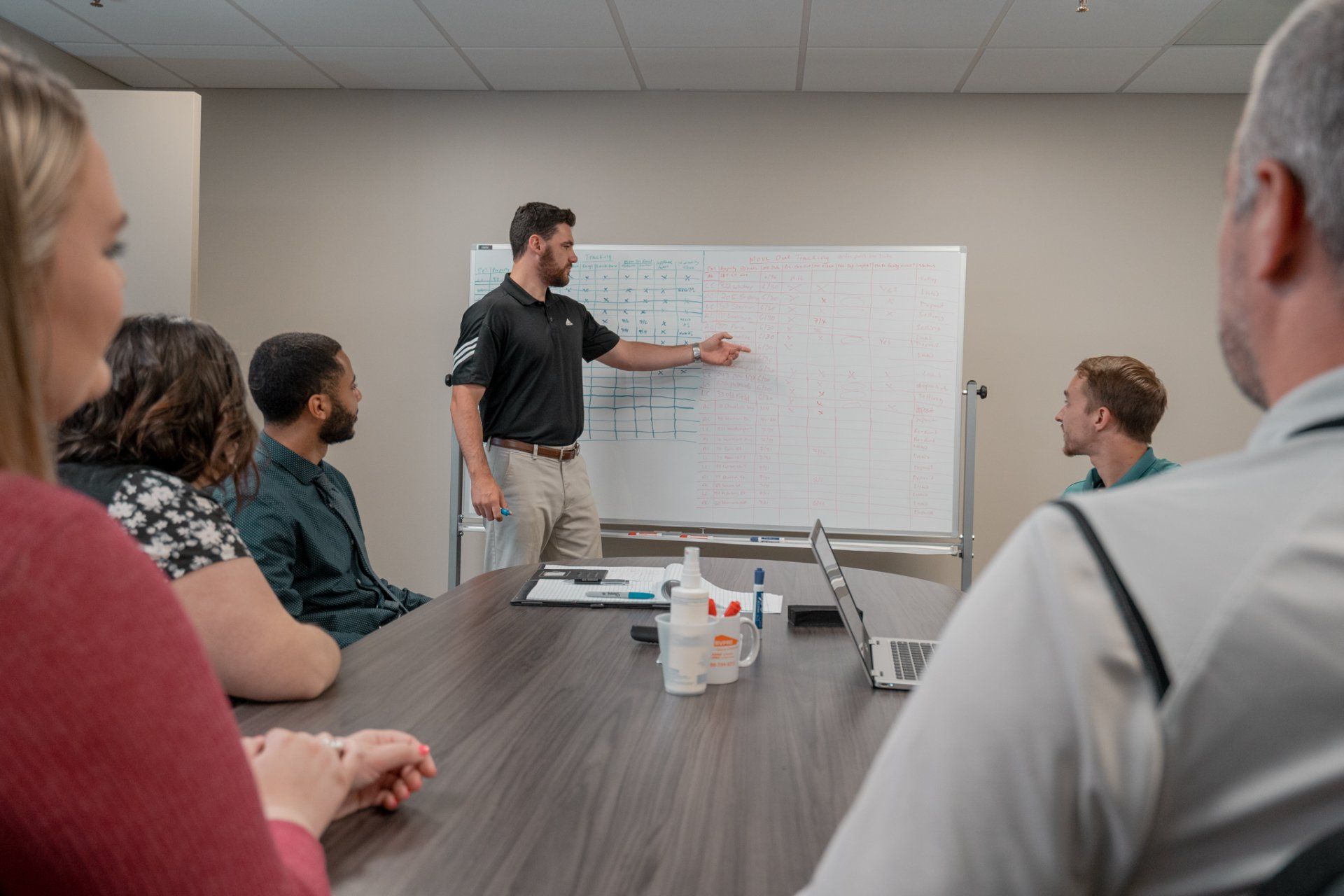 A man is giving a presentation to a group of people in a conference room.