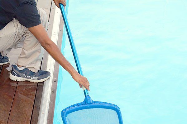 Pool Accessories — Worker Cleaning the Pool in Northshore Chicago, IL Pool Accessories — Worker Cleaning the Pool in Northshore Chicago, IL