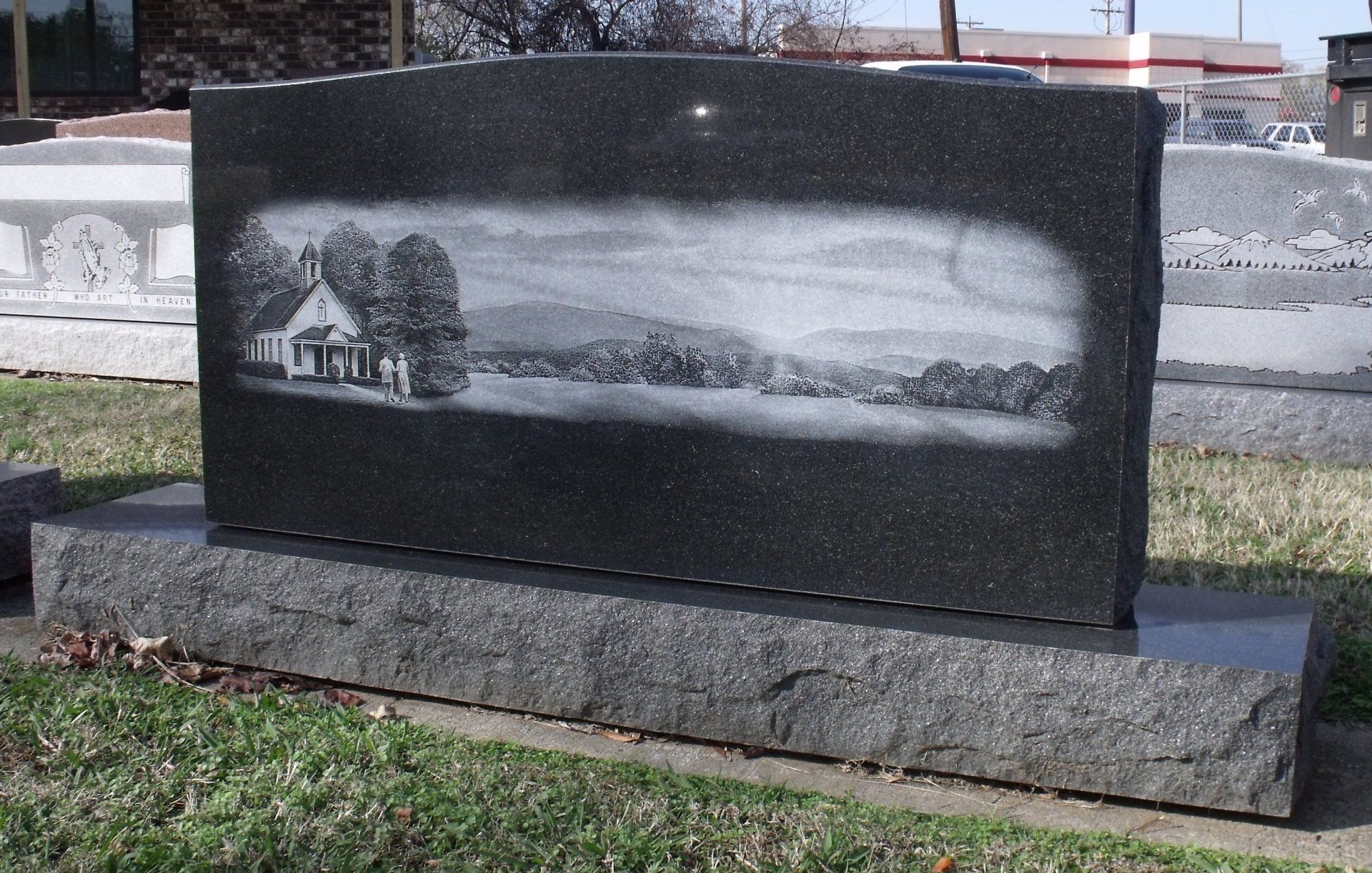 A gravestone with a picture of a church on it