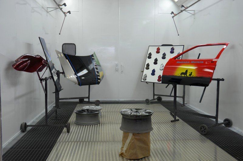 Indoor-Crashtestlabor mit zwei montierten Autotüren und Vordersitzrahmen auf einem Metallboden.