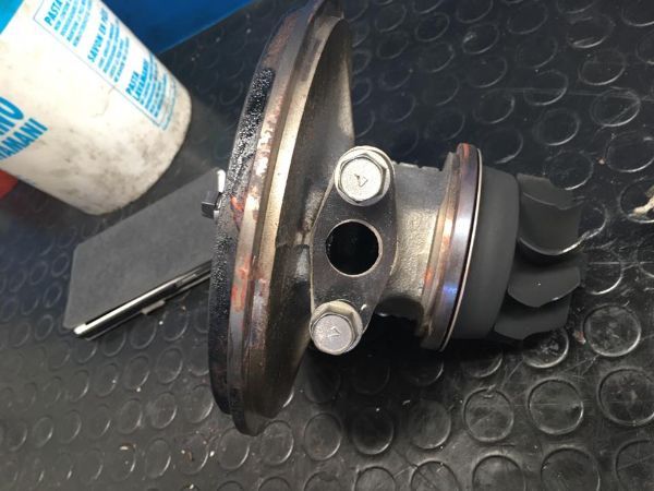 Un gruppo turbina turbocompressore smontato è posizionato su un tappetino da lavoro in gomma nera e ruvida.