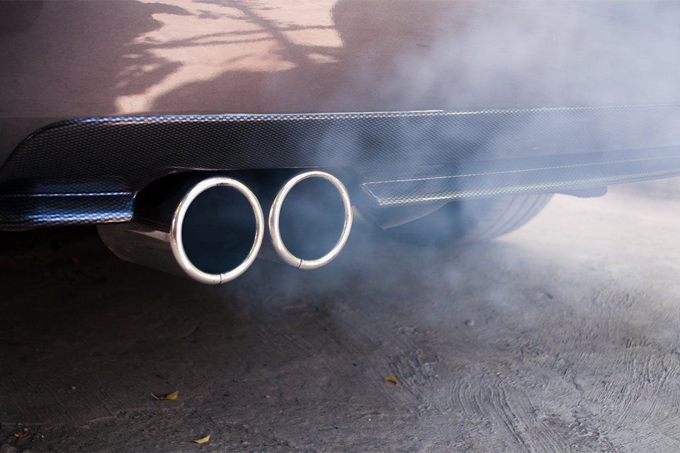 Smoke is coming out of the exhaust pipe of a car.