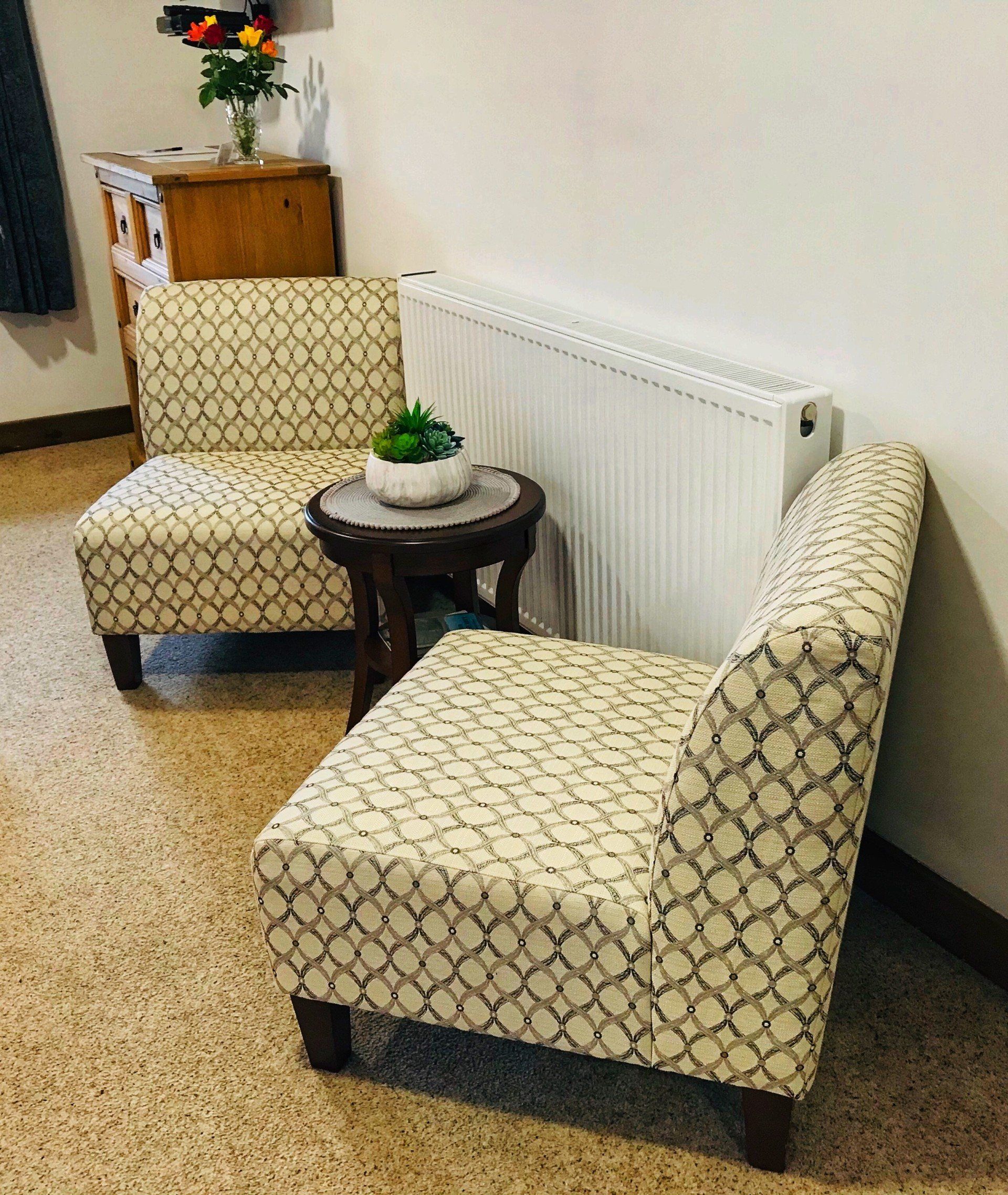 2 comfy chairs and small side table next to a warm radiator