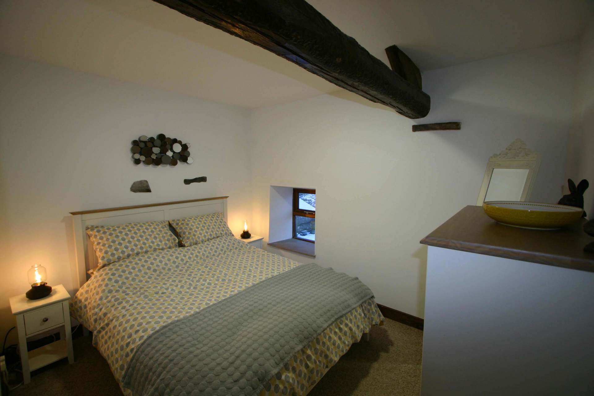 Comfy double bed with duvet and large wooden beam overhead