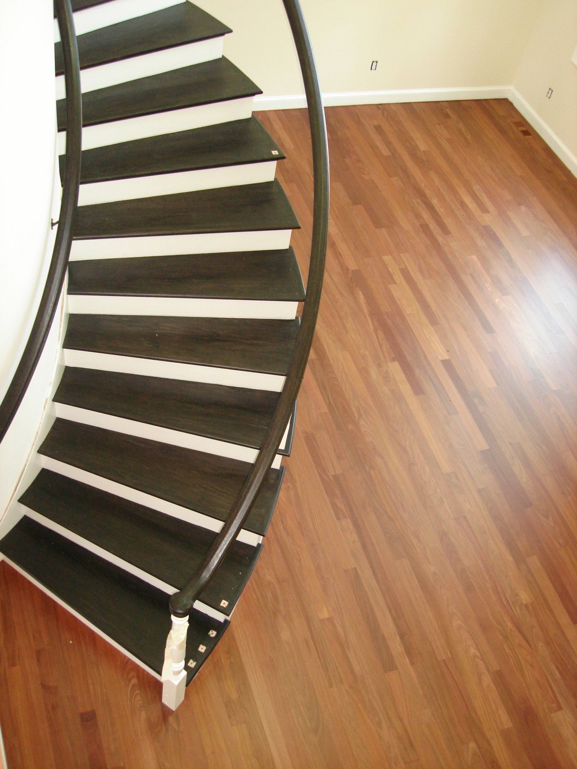A spiral staircase with black and white steps on a wooden floor