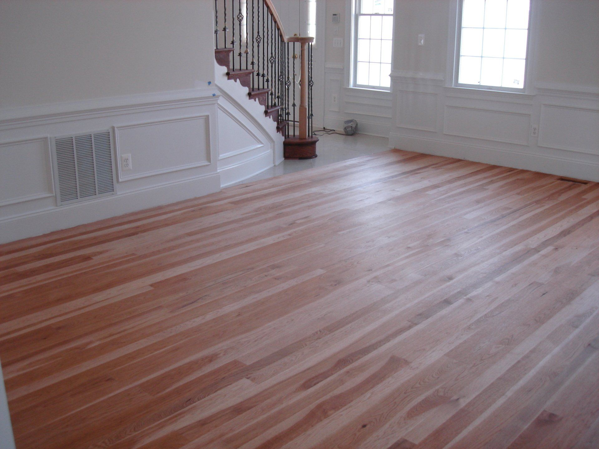 An empty room with a wooden floor and stairs
