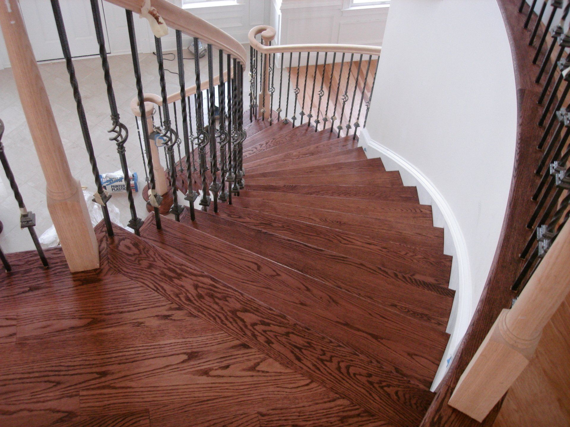 A wooden staircase with a wrought iron railing