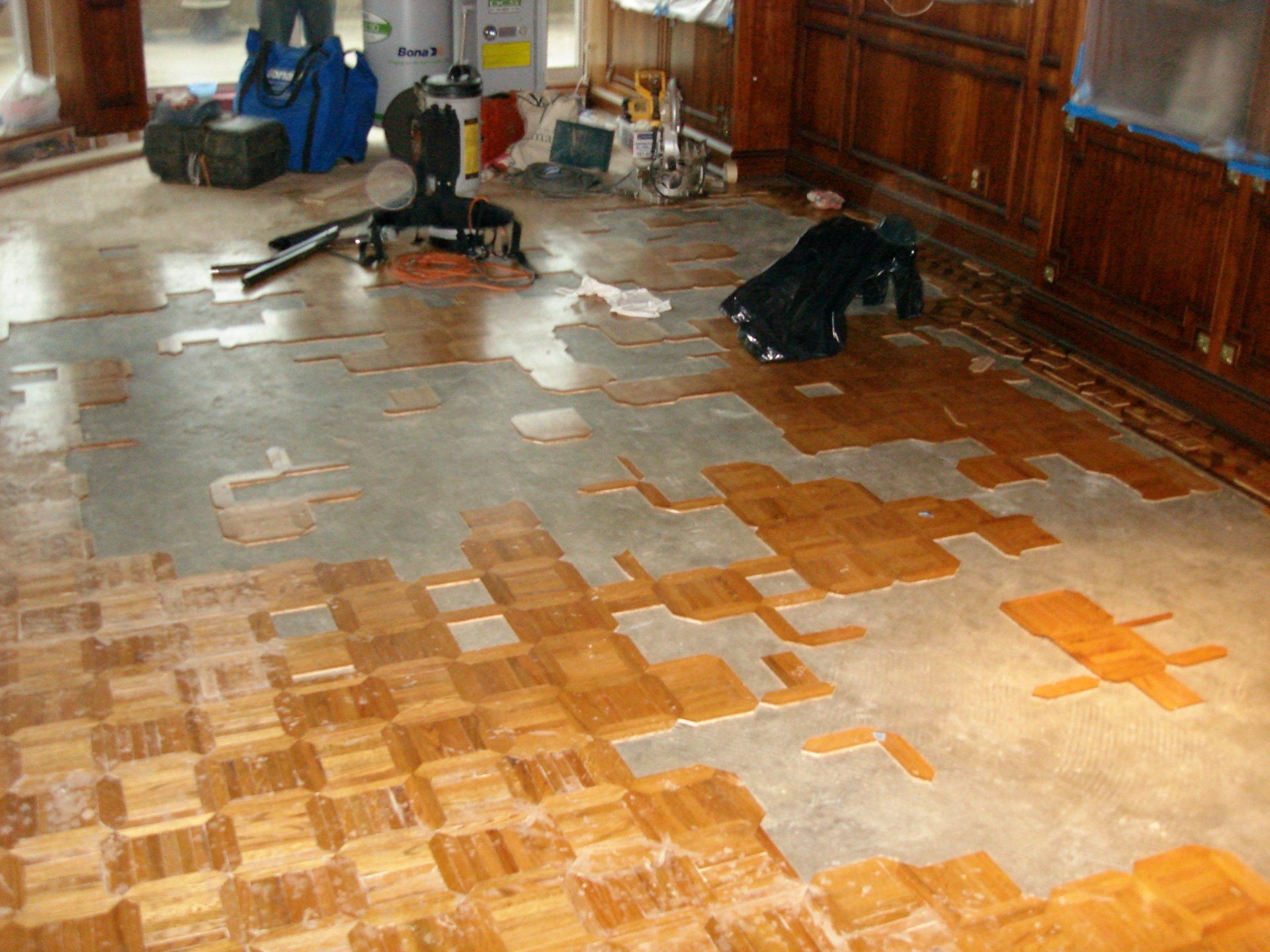 A wooden floor is being painted in a room