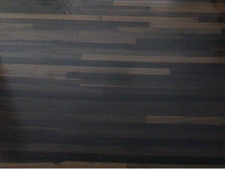 A dark wooden floor with a few lines on it