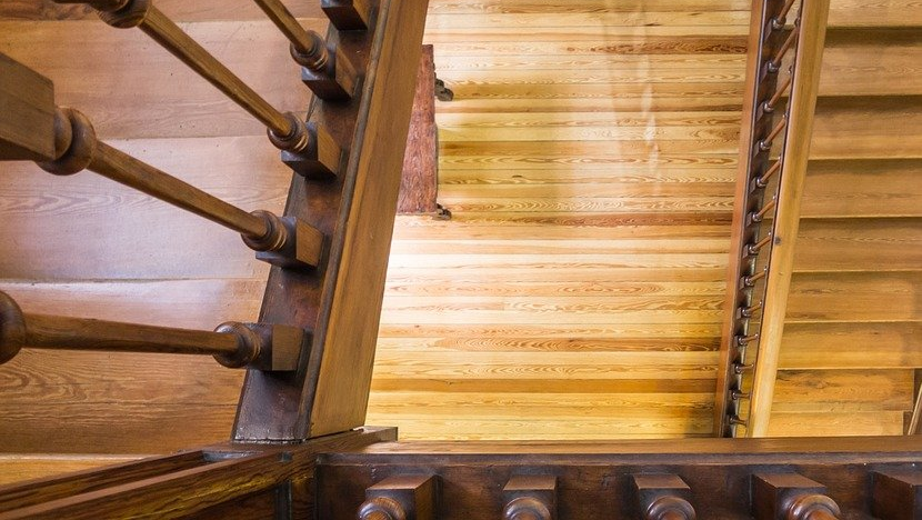 A close up of a wooden staircase with a metal railing