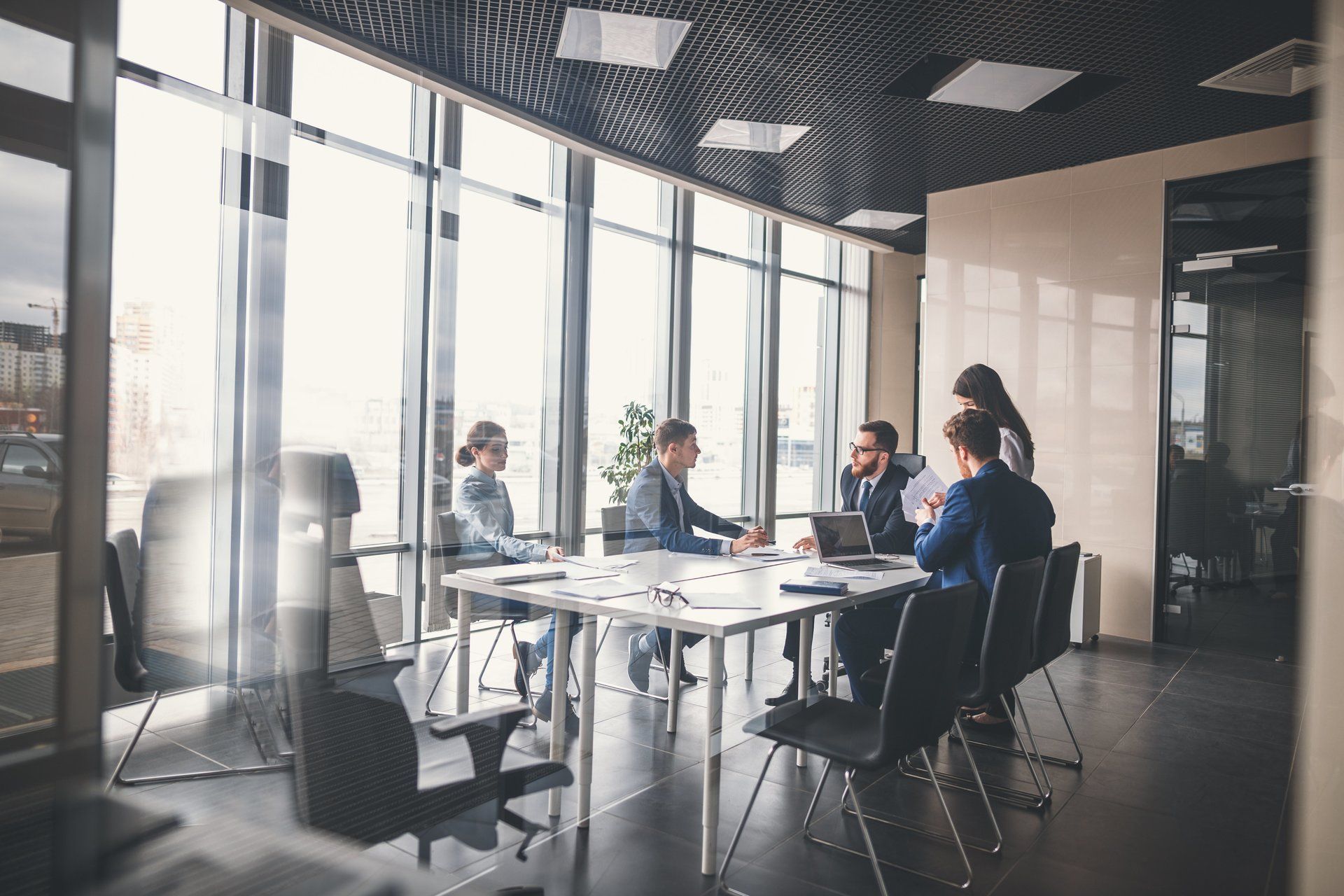 A group of people are sitting around a table in a conference room.