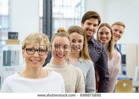 A group of people are standing in a row and smiling.