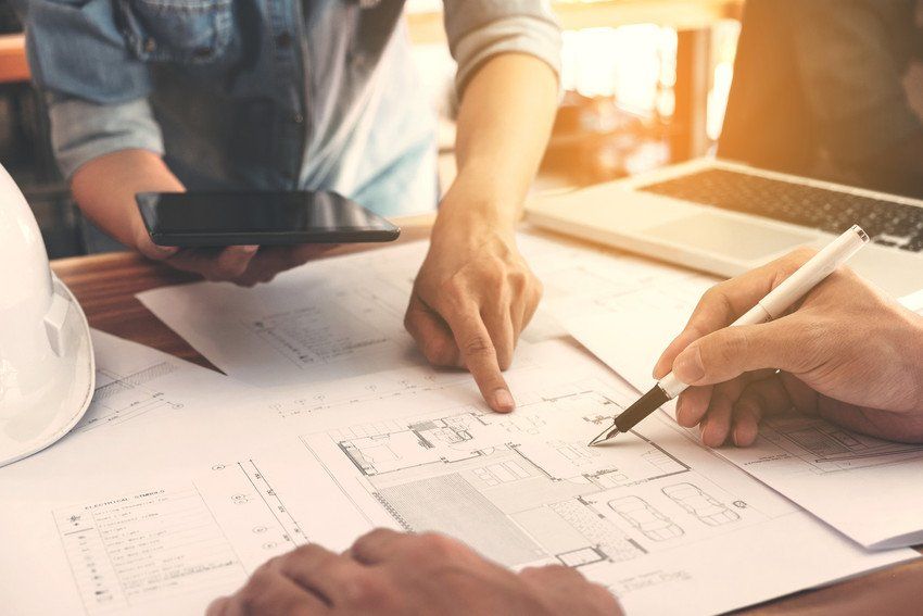 Engineers working with architectural plans on paper