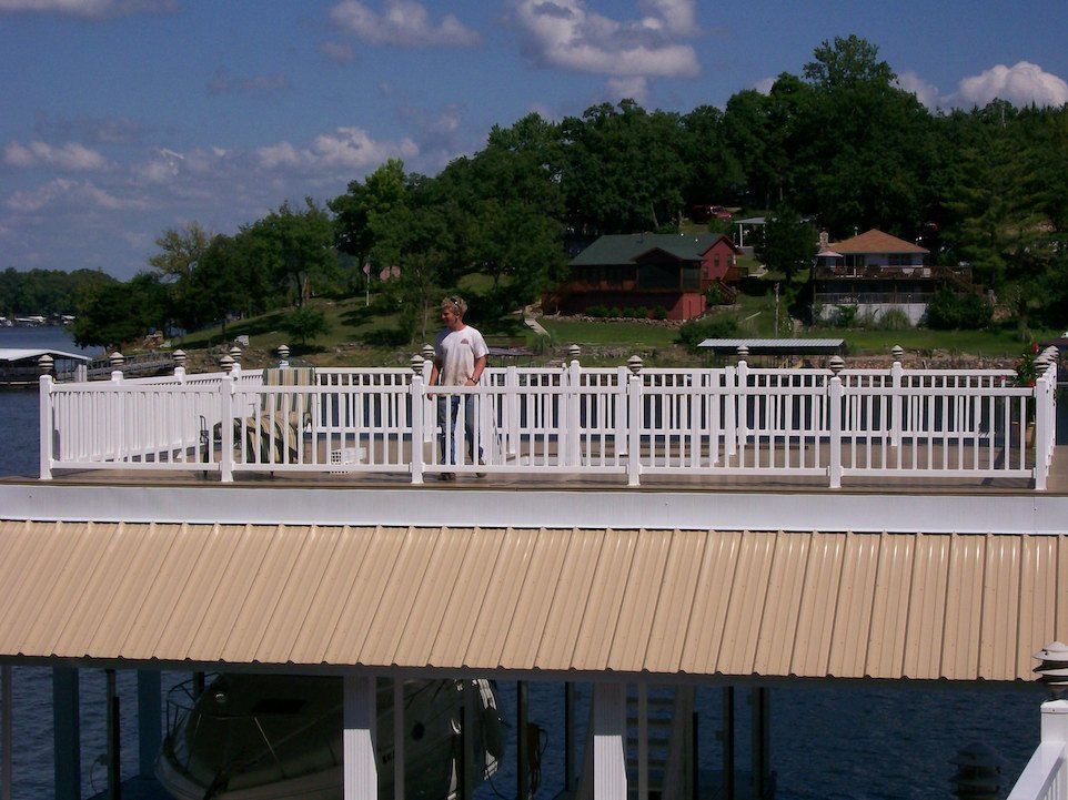 White pergola attached to a white house with a pool in the foreground.