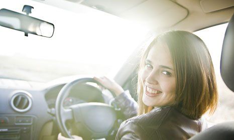 A girl smiling white driving
