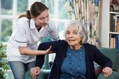 Elderly woman being taken care of by a young carer