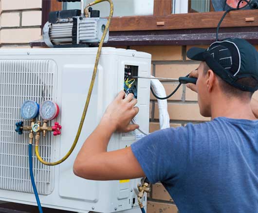 Man Repairs the Air Conditioner — Zachary, LA — Hughes Mechanical Contractors Man Repairs the Air Conditioner — Zachary, LA — Hughes Mechanical Contractors