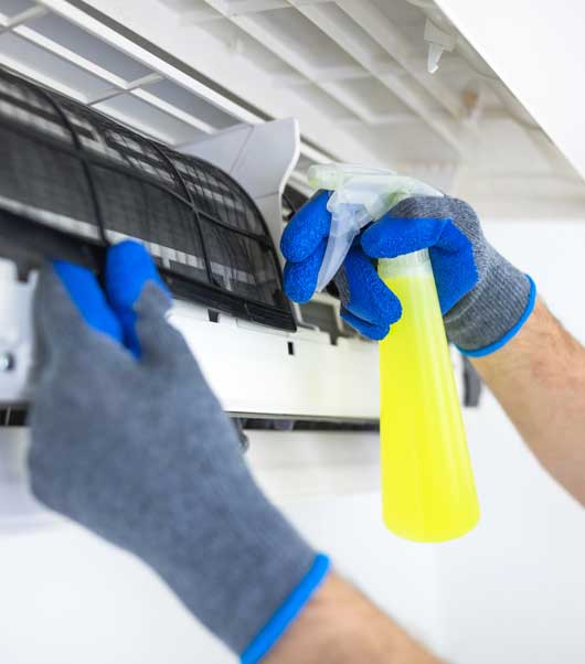 Worker Cleaning the Air Condition — Zachary, LA — Hughes Mechanical Contractors