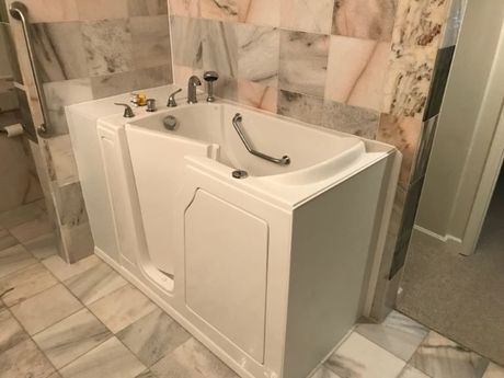 Walk-in Tub Install Hot Springs AR A walk in bathtub is sitting in a bathroom next to a tiled wall.