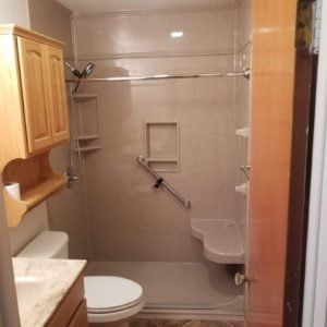 A bathroom with a toilet a sink and a walk in shower