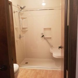 A bathroom with a walk in shower and a toilet.