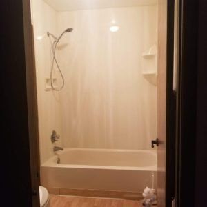 A bathroom with a tub , shower and toilet.