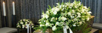 cuscinetto di fiori bianchi su bara
