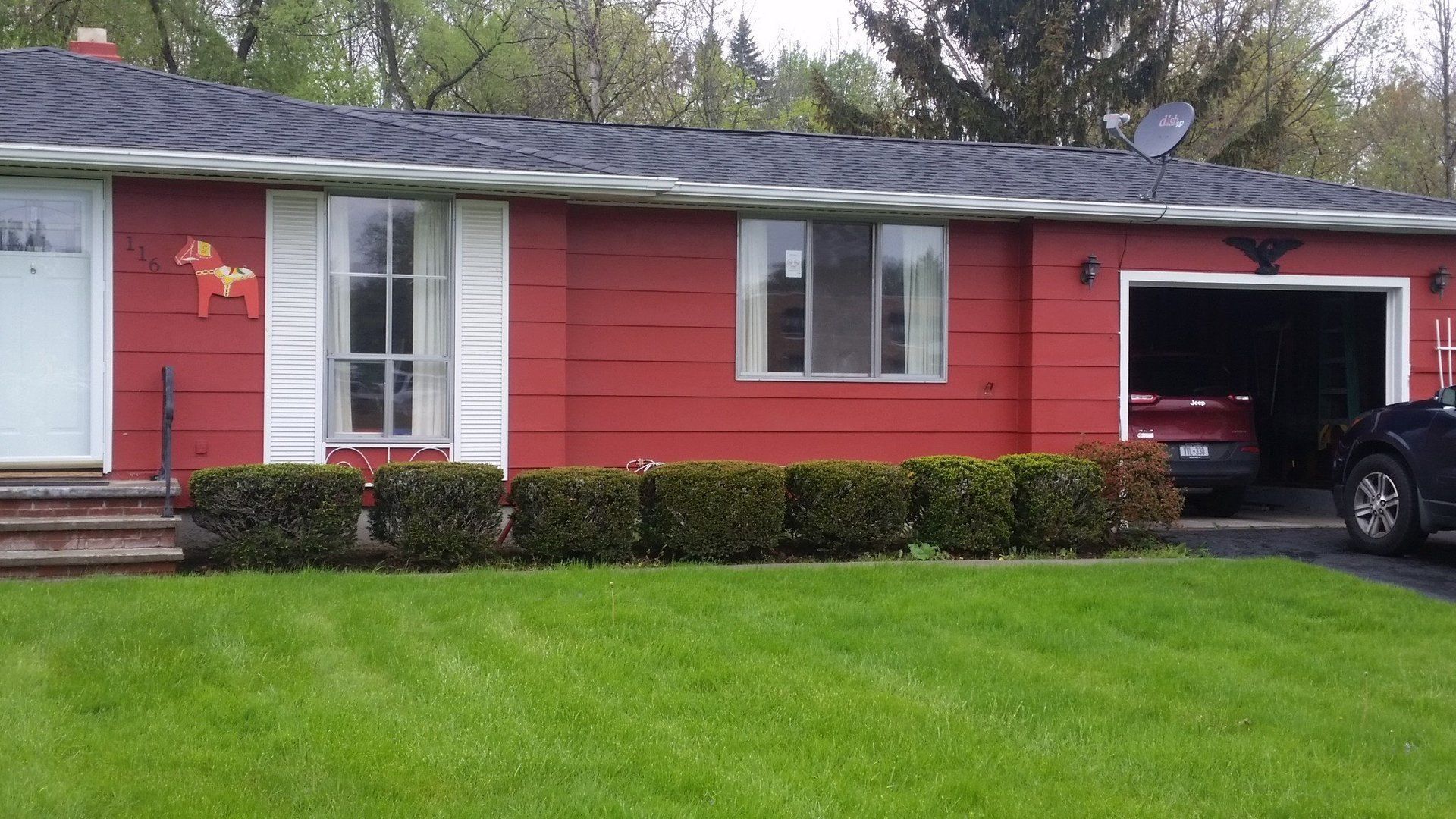 shrubs in front of red house