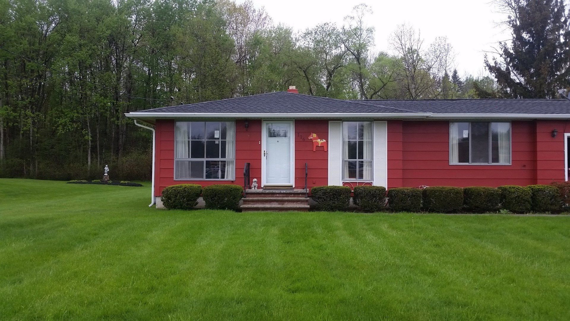 shrubs in front of red house