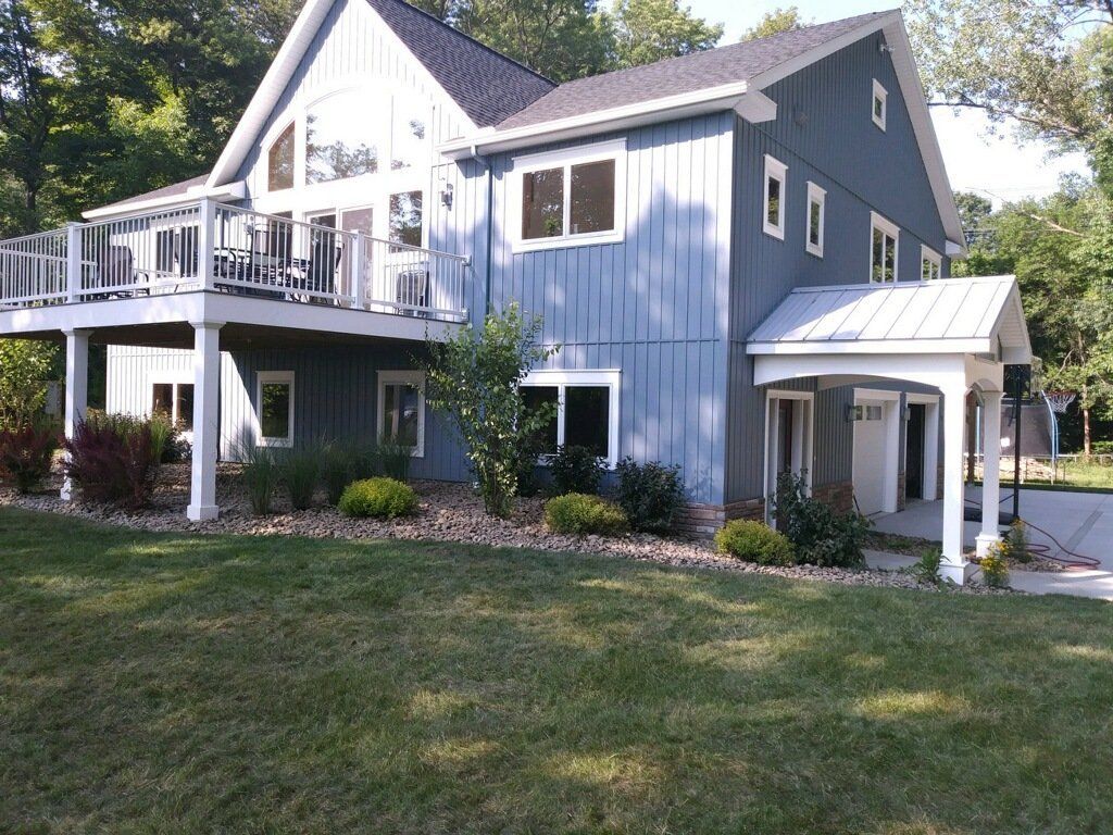 back of blue house with landscaping services
