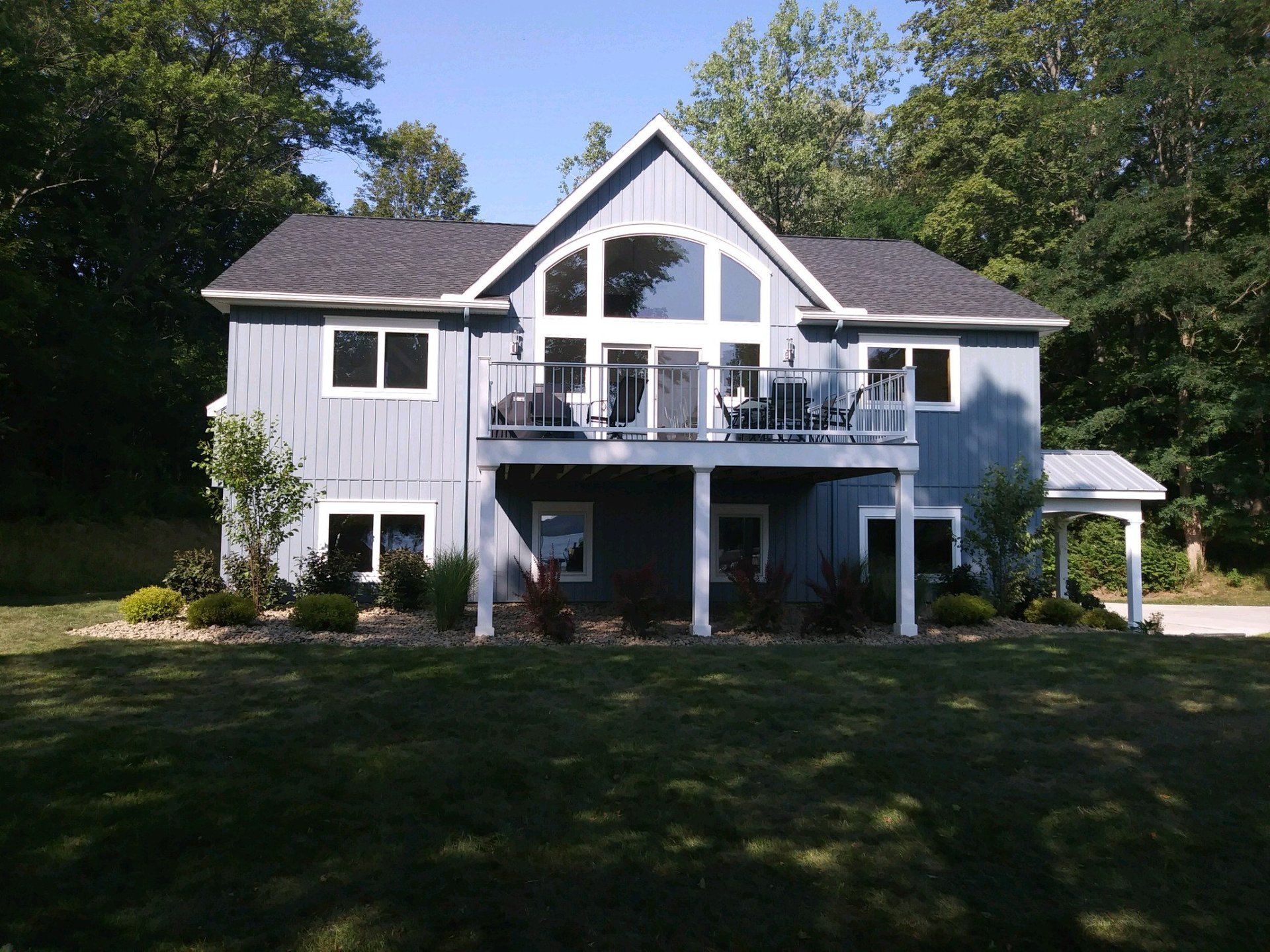 back deck of blue house and landscaping