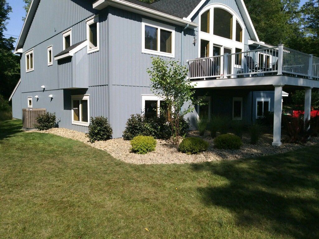 side of blue house with landscaping services