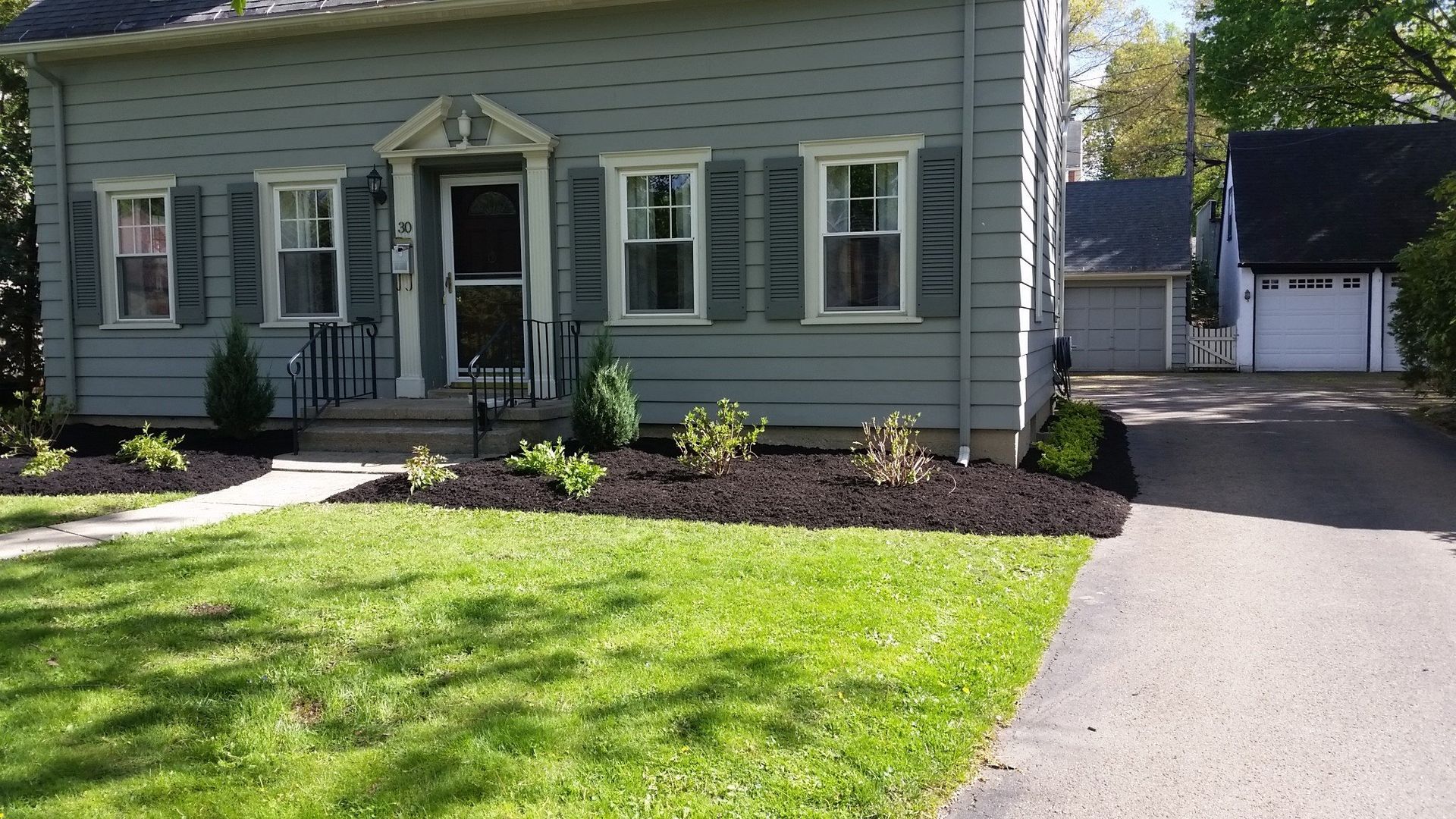 front of gray house with landscaping