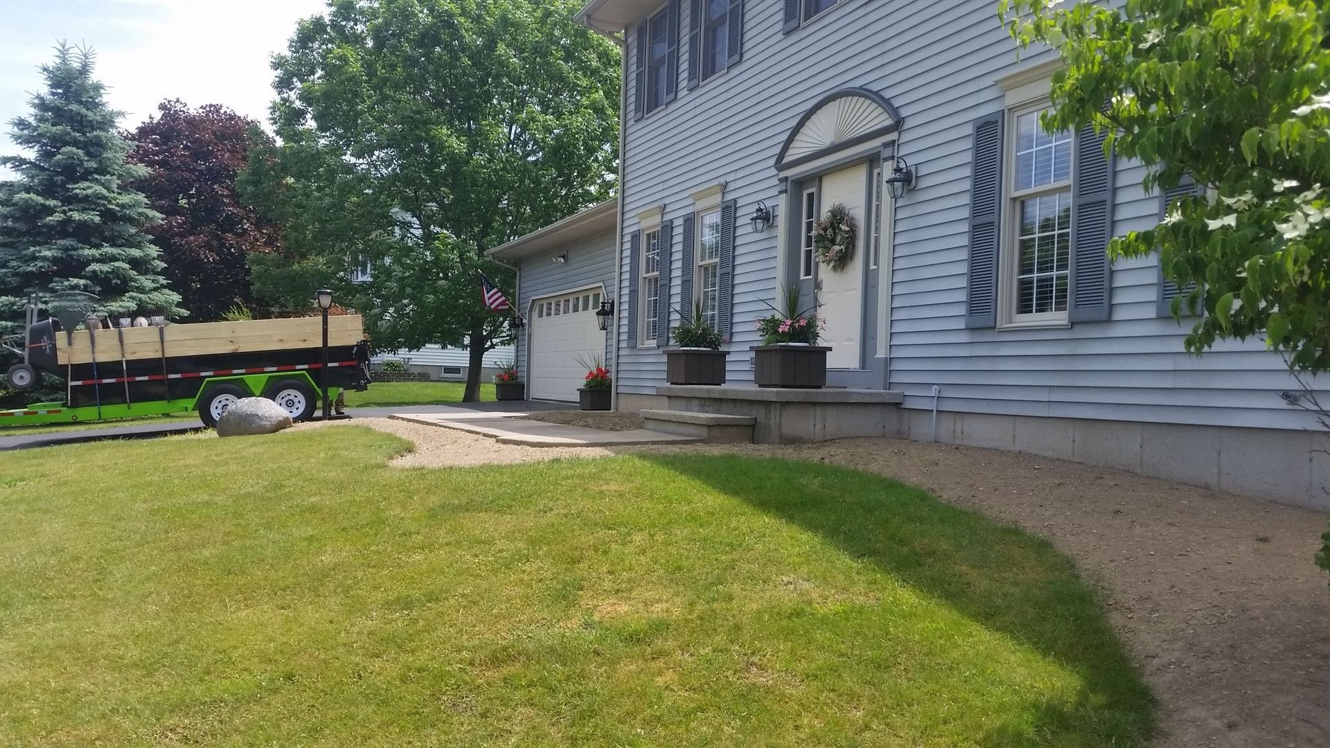 empty flowerbed in front of blue house