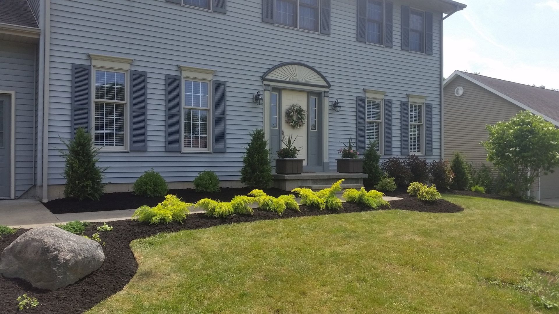 flowerbed in front of blue house