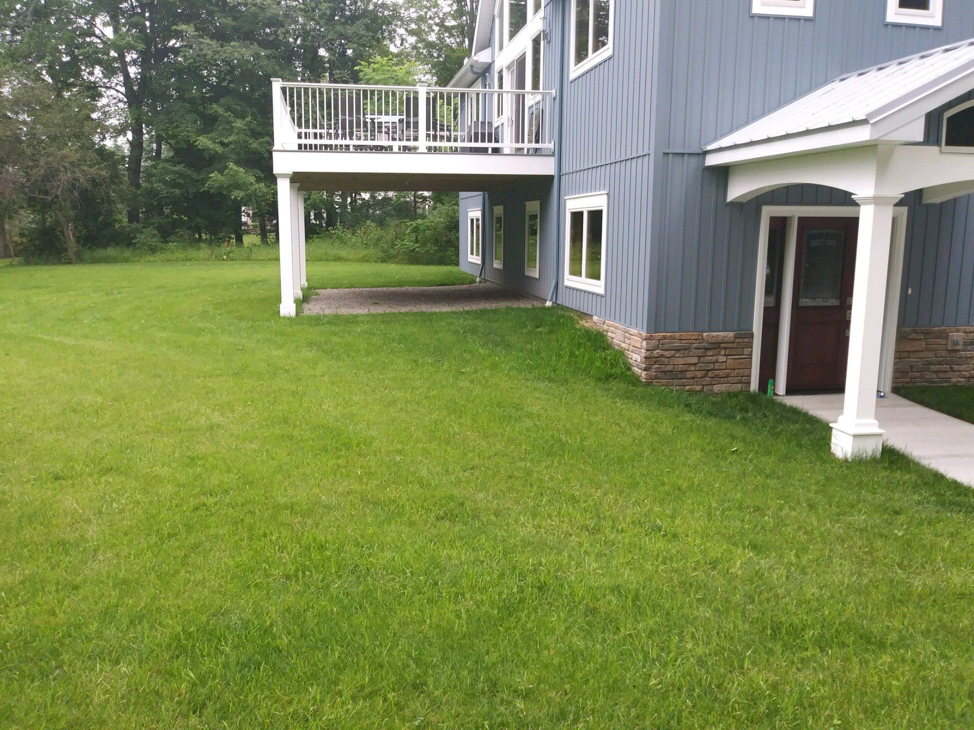side of blue house without landscaping